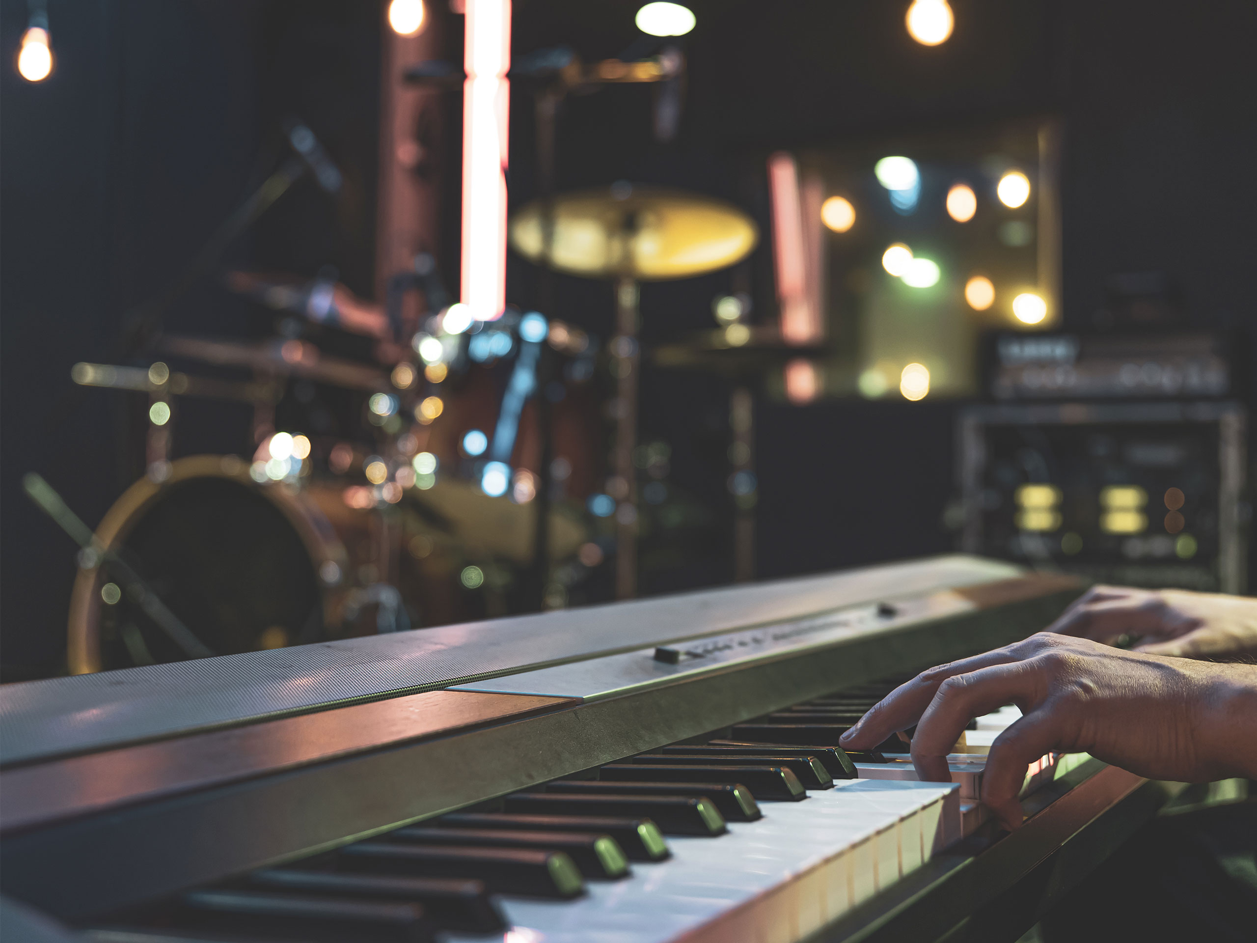 Close up of pianist's hand on musical keys on blurred background. BH Audio